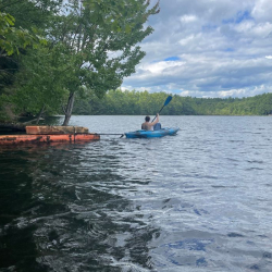 Person in kayak towing wood from an old shed