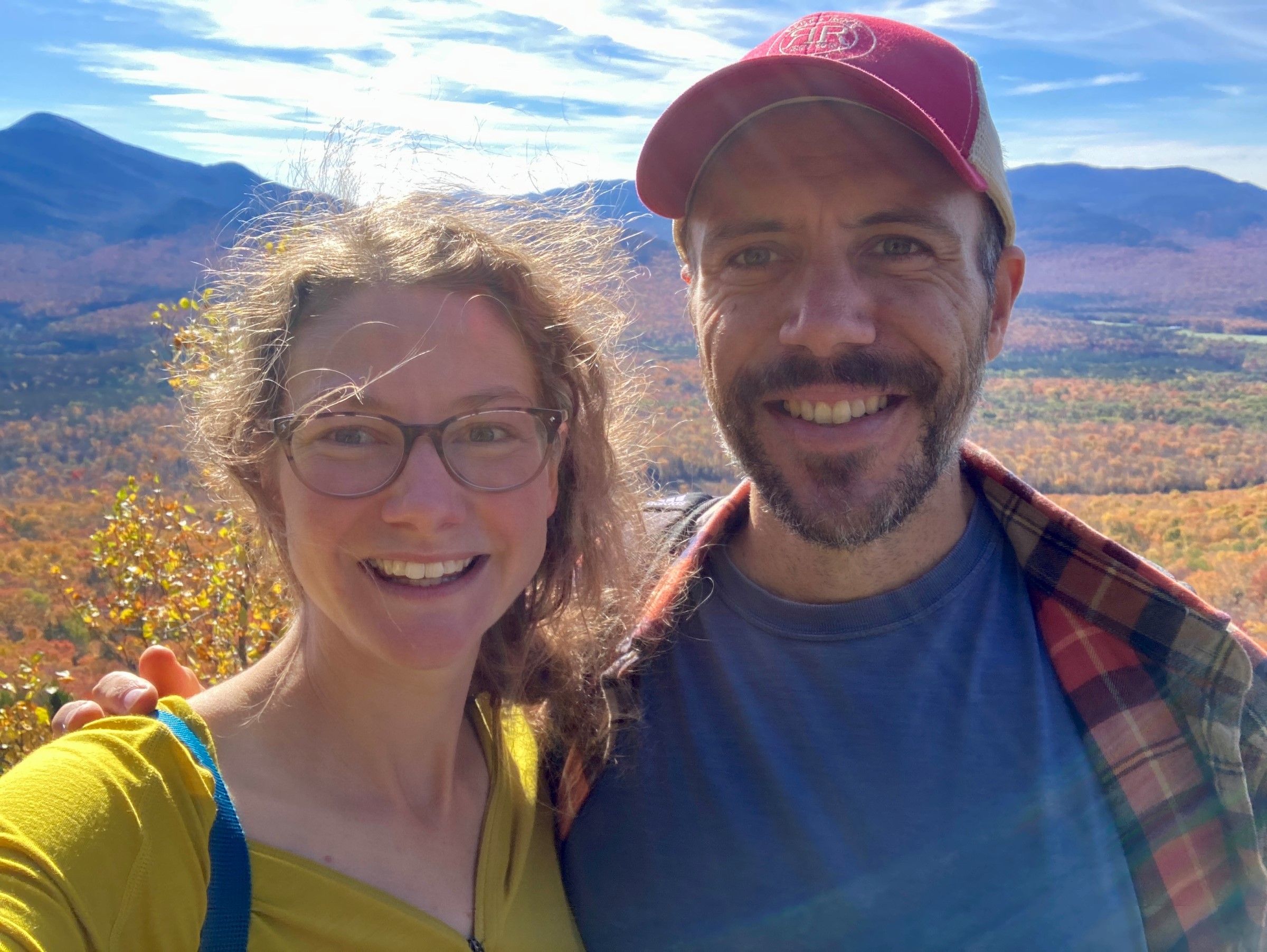 Couple with fall foliage in the background.